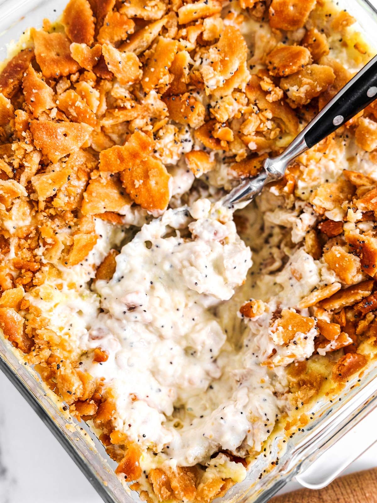 overhead close up photo of poppy seed chicken casserole in glass dish