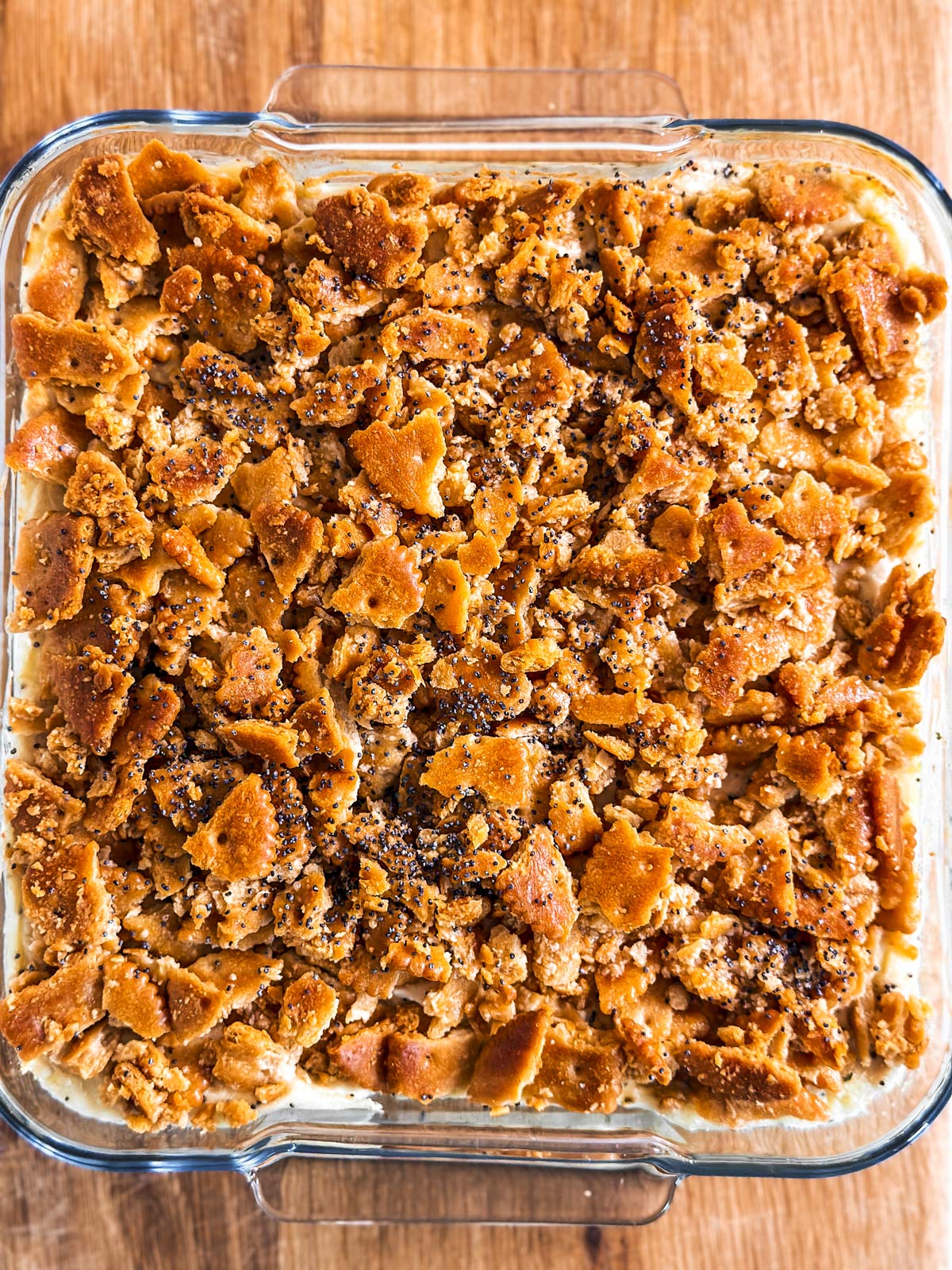 overhead view of baked poppy seed chicken casserole in square glass dish