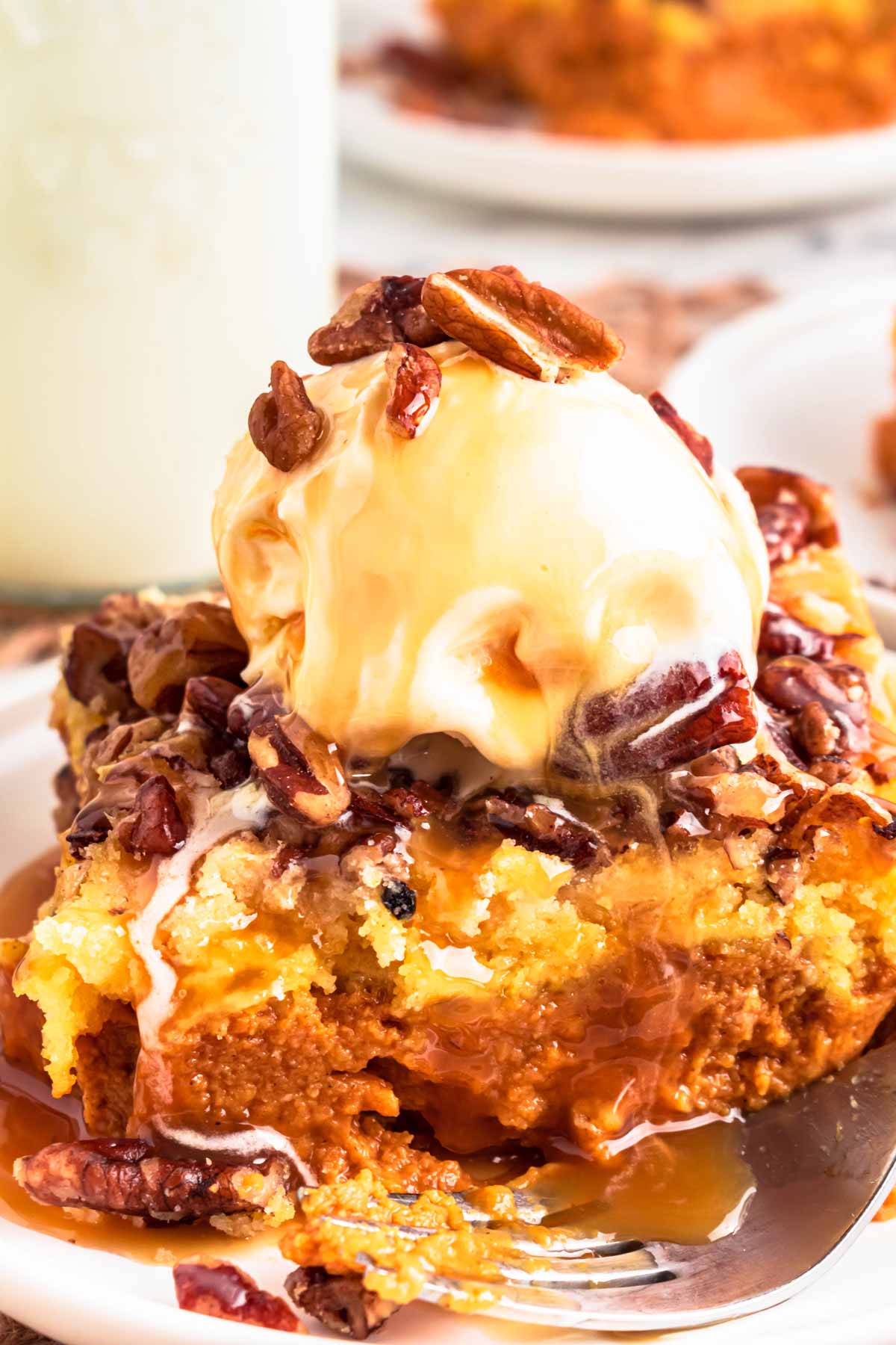 frontal view of pumpkin dump cake slice topped with ice cream