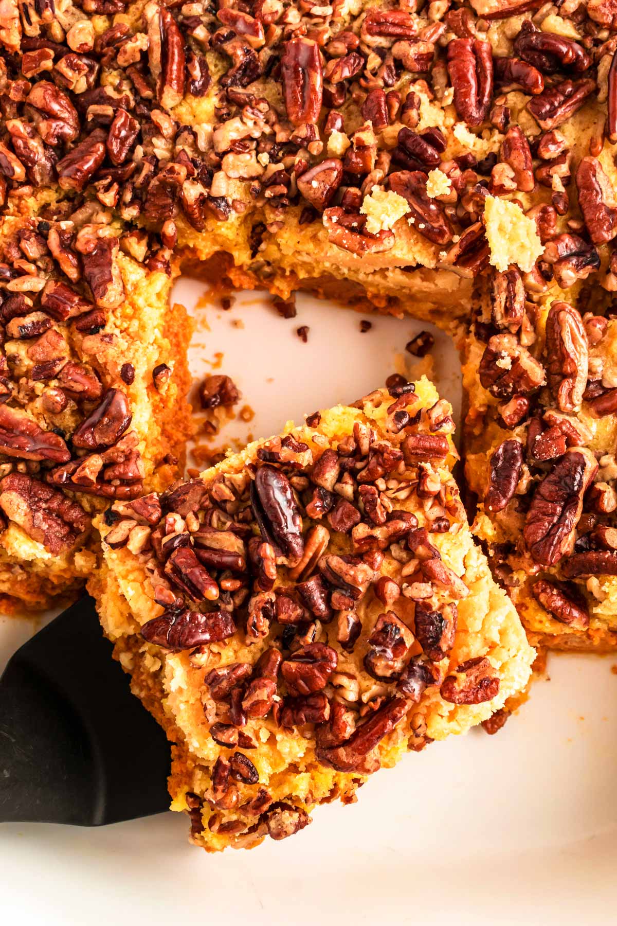 spatula grabbing a slice of pumpkin pecan dump cake