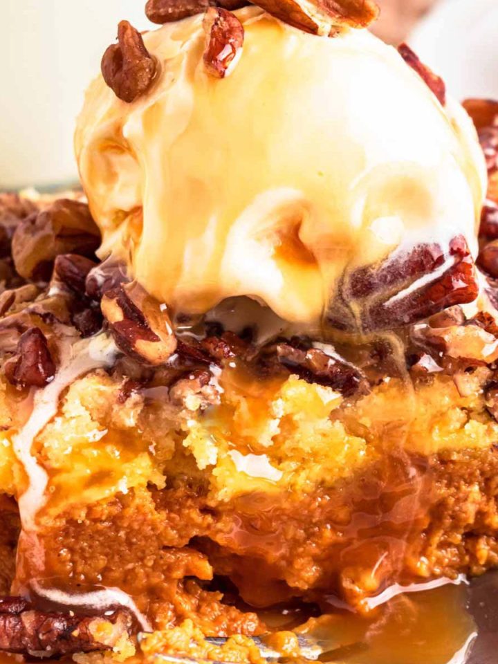 frontal view of pumpkin dump cake slice topped with ice cream